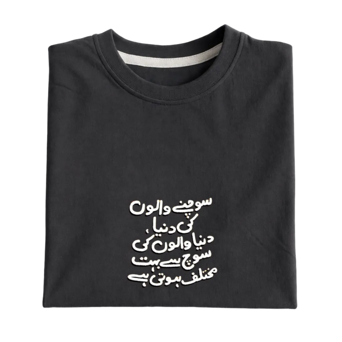 Folded black sweatshirt with white Arabic text on a light gray background