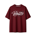 A maroon short-sleeve t-shirt with a white 'VibeZ9' script graphic on the chest, embellished with small blue and black rhinestone details, shown against a plain white background.