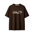 A dark brown short-sleeve crewneck t-shirt with 'VibeZ9' printed in a cream-colored cursive font across the chest, shown against a plain white background.