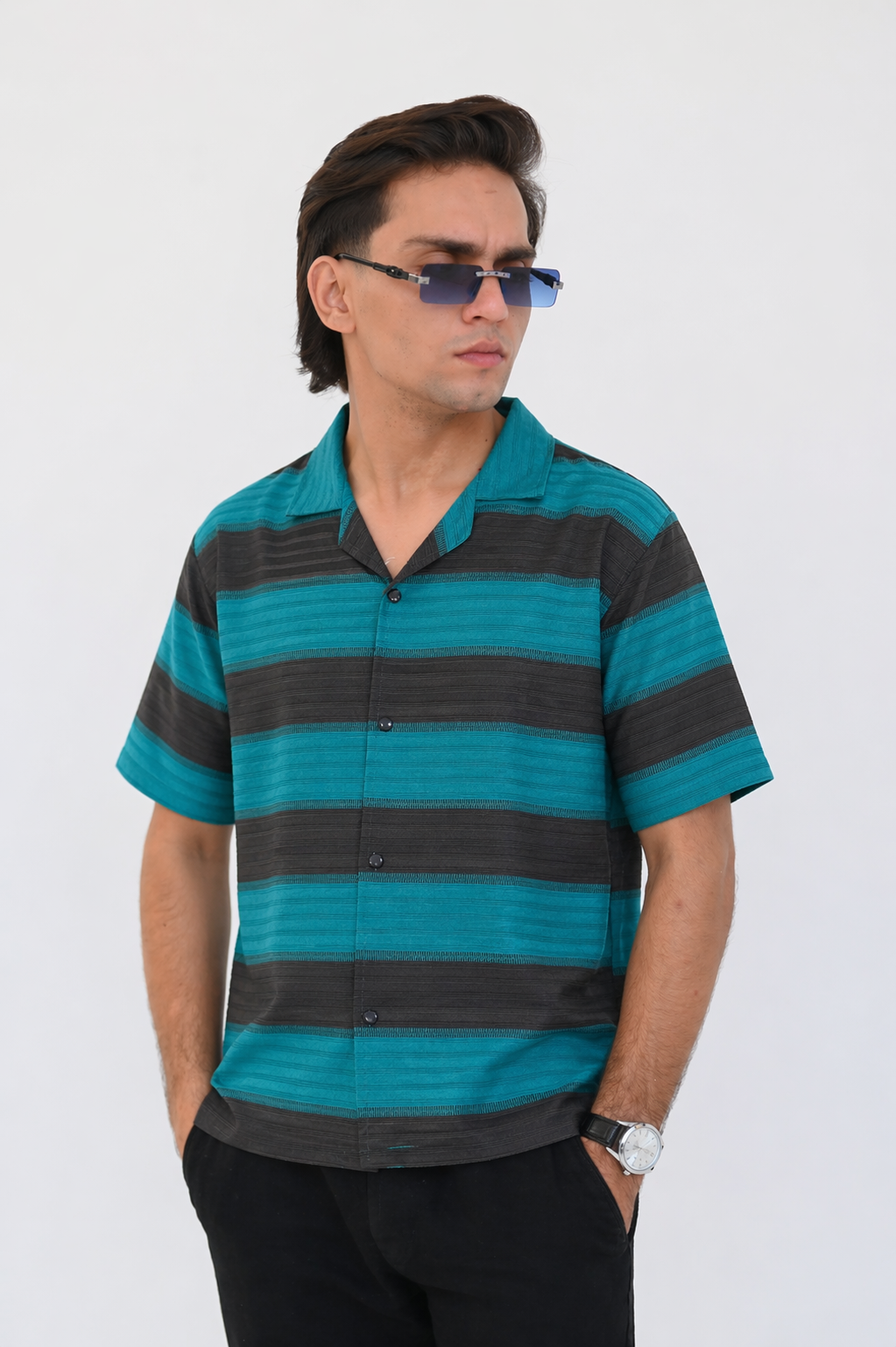 Man wearing a striped shirt and sunglasses against a white background