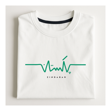 A folded white crewneck t-shirt with a green heartbeat line graphic and the word 'ZINDABAD' printed in black below it, displayed on a light off-white background.