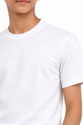 Person wearing a plain white t-shirt against a white background
