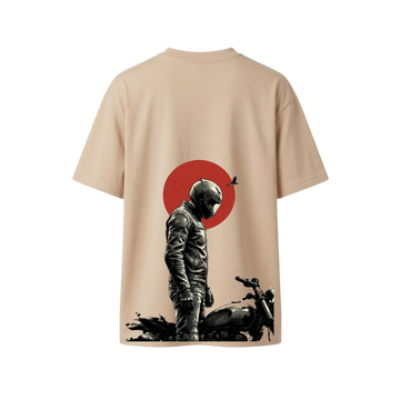 A beige short-sleeve t-shirt shown from the back, featuring a graphic print of a motorcycle rider in black and gray standing in front of a red circle.