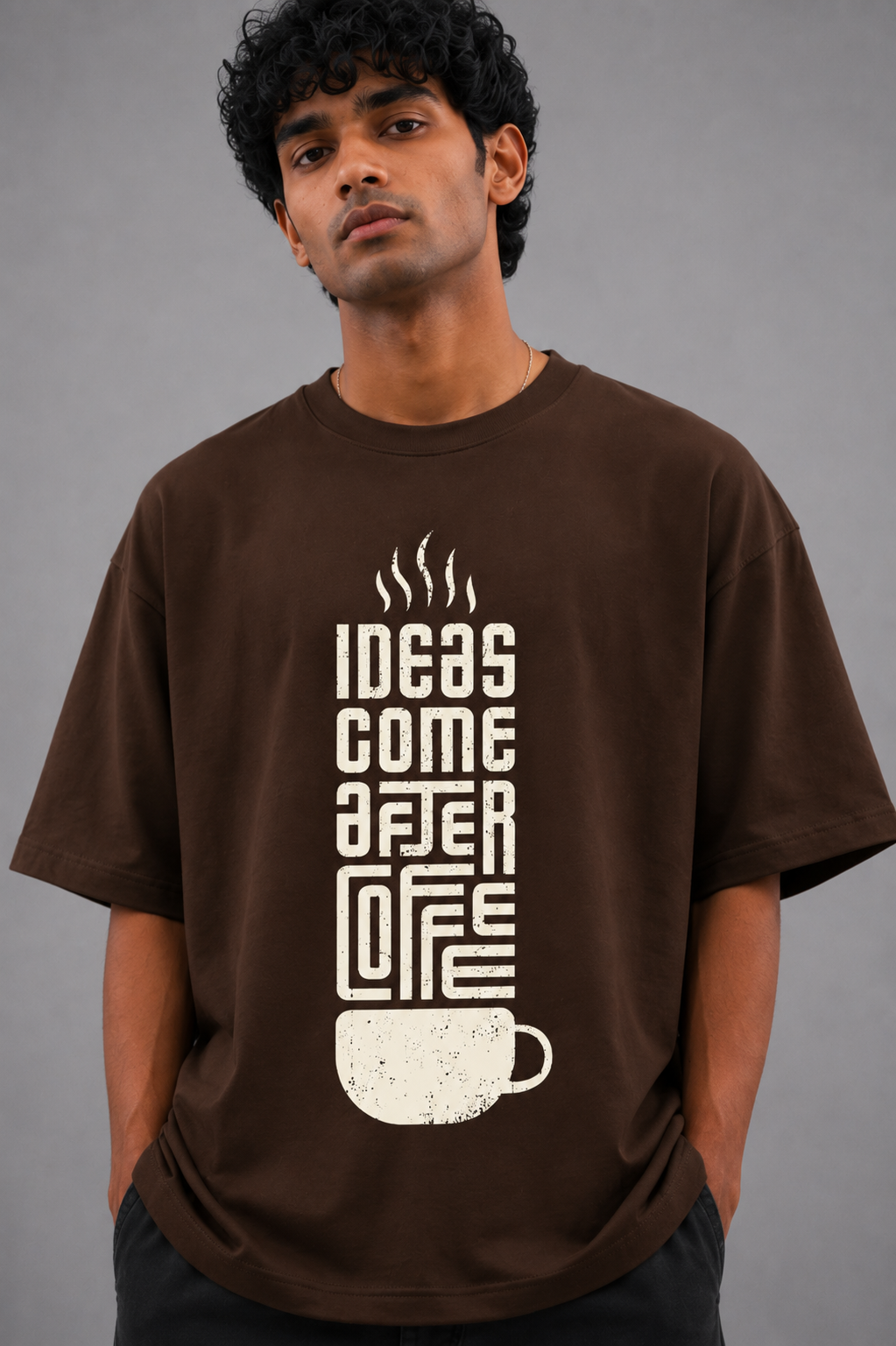 Man wearing a brown t-shirt with a coffee-themed design on a gray background
