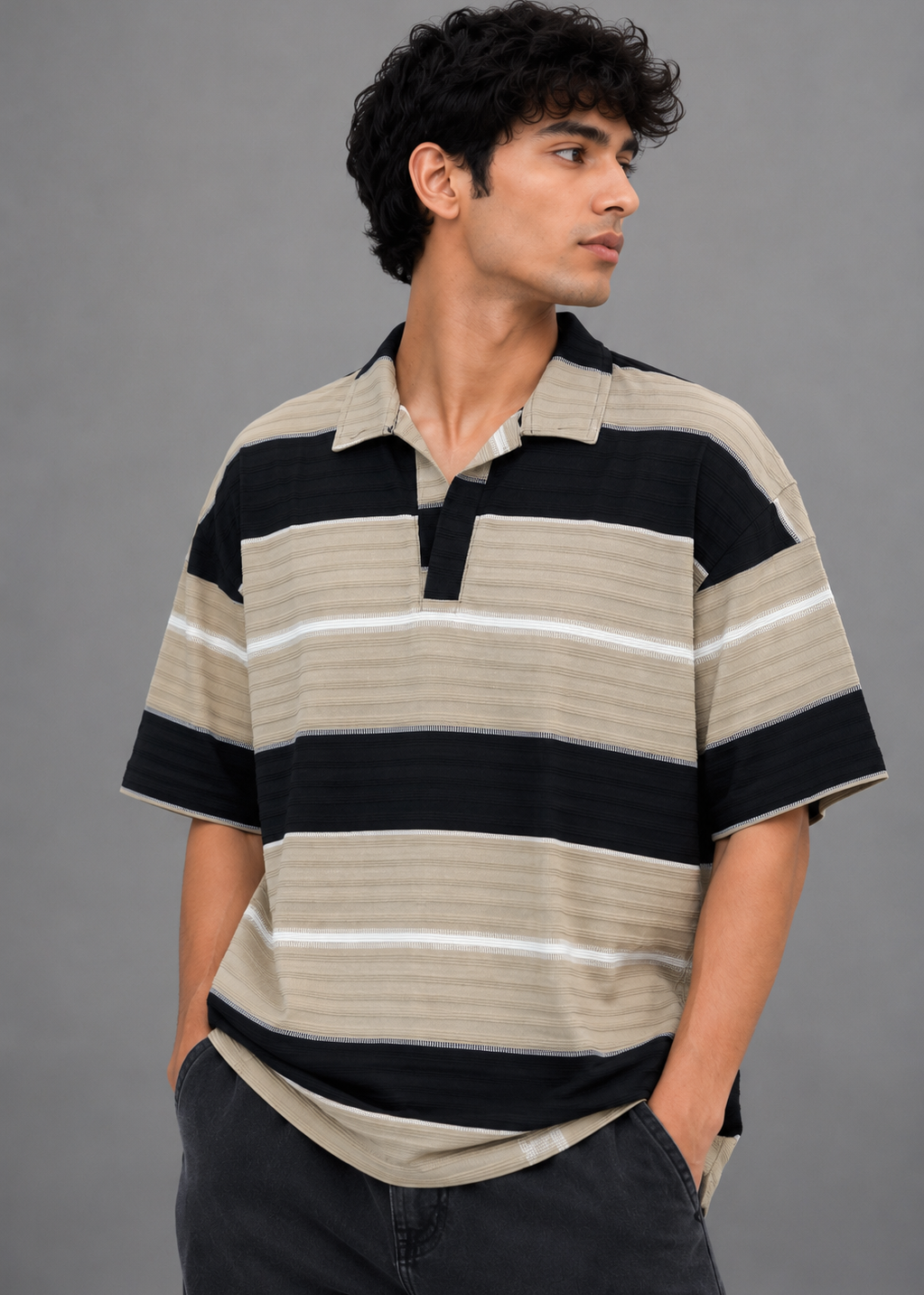 Man wearing a striped polo shirt against a gray background